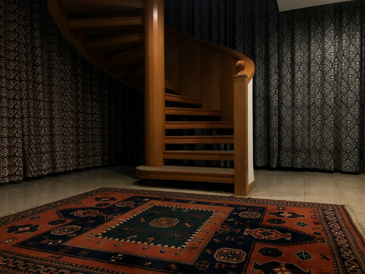 a spiral staircase in a house with a rug on the floor